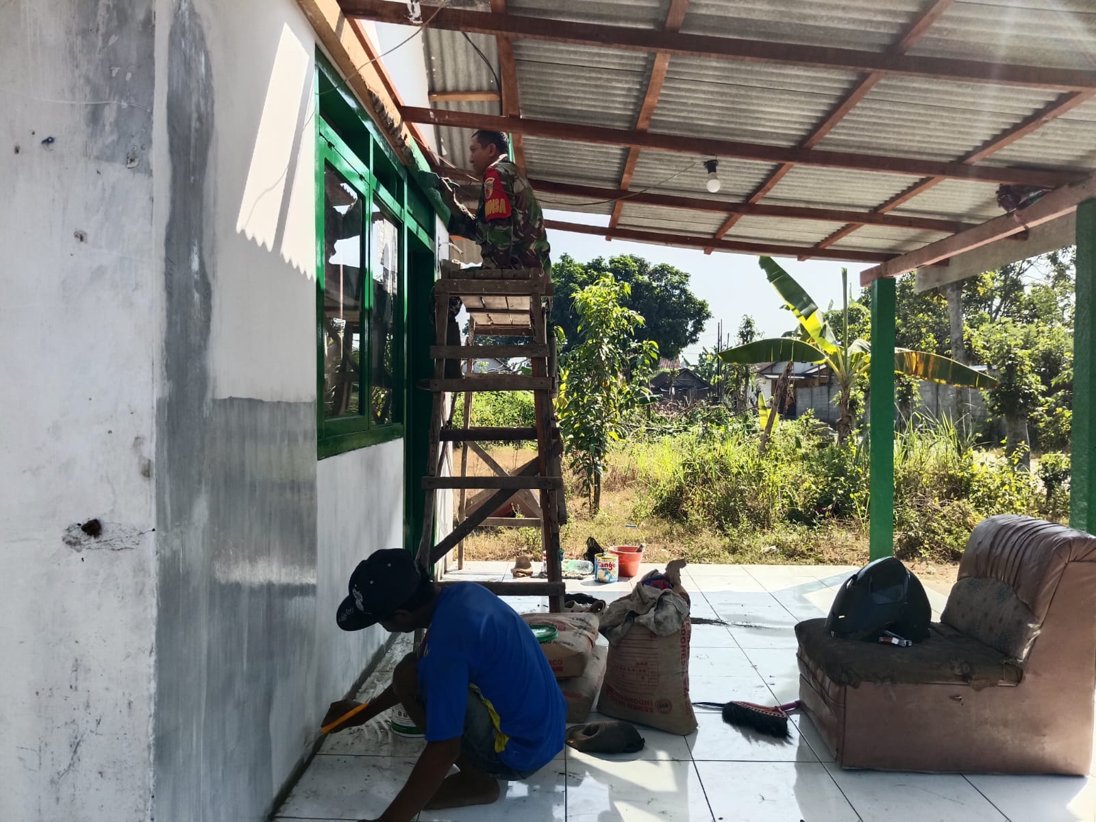 Babinsa Bukur Dampingi Pengecatan Gawang Rumah Penerima Bantuan Rutilahu Gubernur Jatim