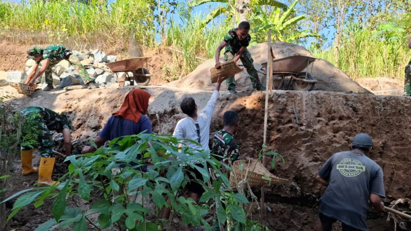 DENGAN SISTIM SANTING-SANTINGAN, WARGA MASYARAKAT BERSAMA TNI PERCEPAT GALIAN PONDASI TALUD