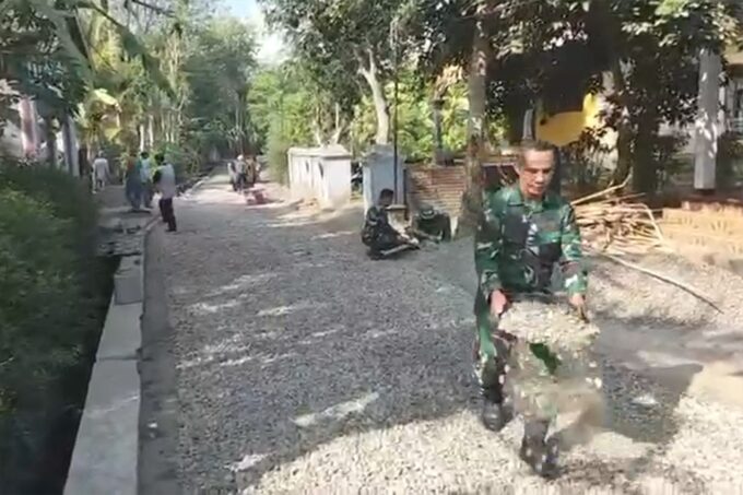 TNI dan Warga Gotong-Royong Aspal Jalan di Desa Pogalan
