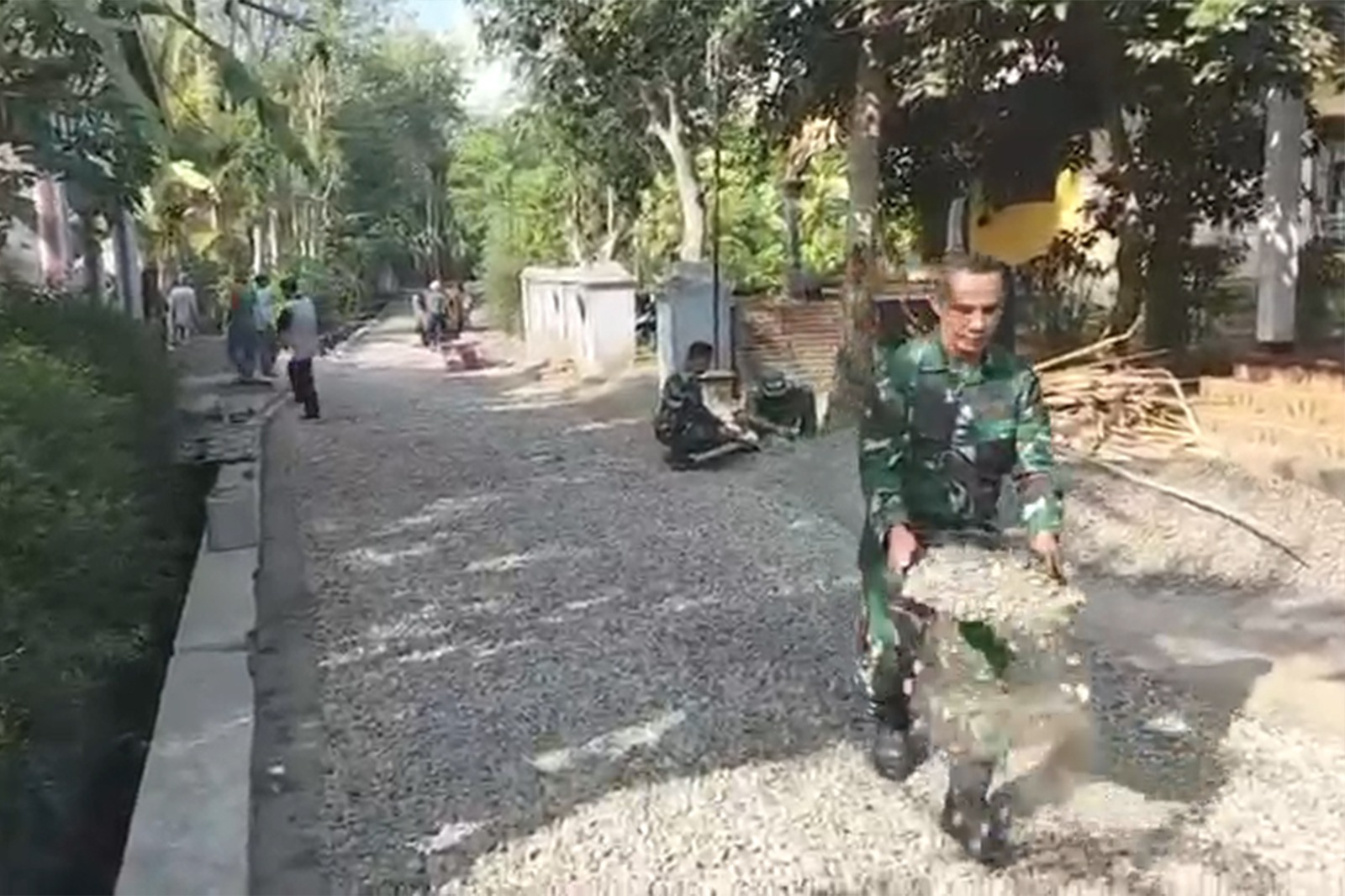 TNI dan Warga Gotong-Royong Aspal Jalan di Desa Pogalan